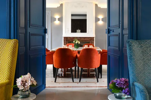 blue french doors open to red chairs around a table