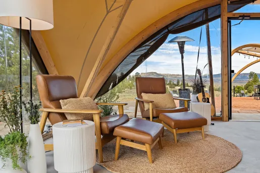 Two reclining chairs in a cabin with a forest in the background