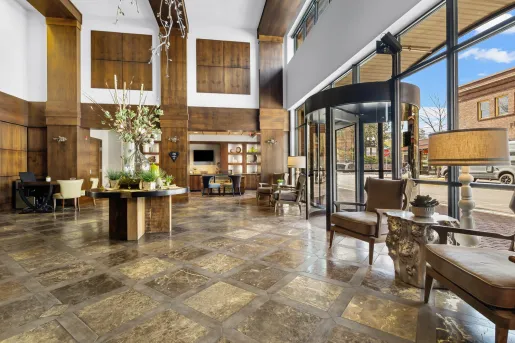 Indoor lobby view with a glass wall and rotating door leading to the outdoors