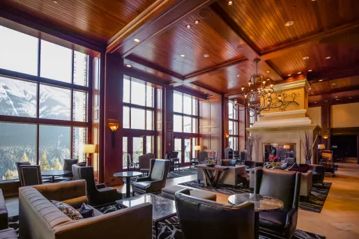 Indoor lounge and seating area with cushioned, leather chairs around coffee tables