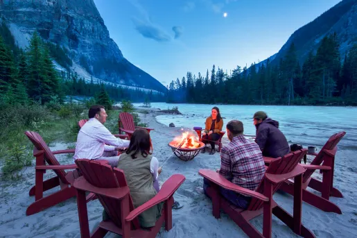 guests sitting in adirondack chairs circled around bonfire