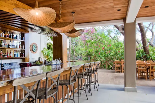 Outdoor patio and bar with wooden bar counters and stone pillars