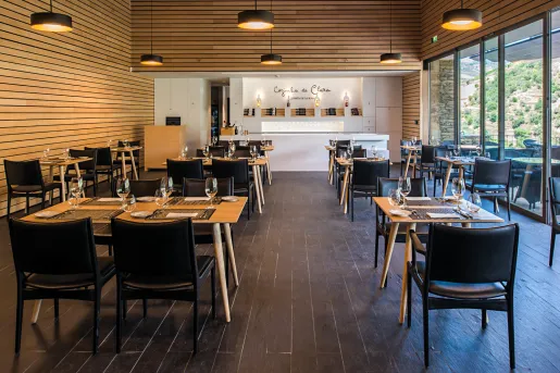 Indoor dining area with wooden tables and black cushioned chairs