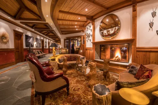 Indoor lodge lobby with wooden furniture and a fireplace