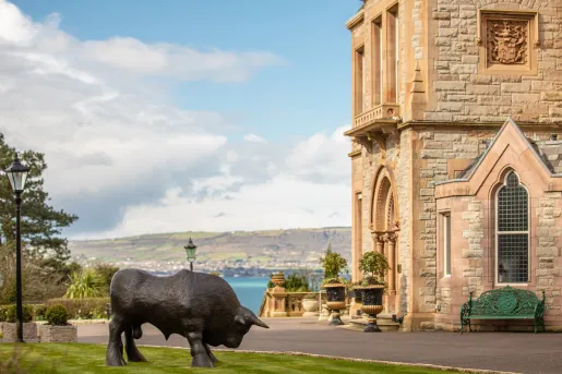 Buffalo statue outdoors next to a stone building