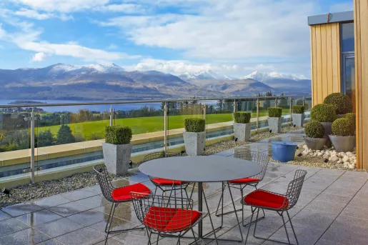 Outdoor patio with stone flooring and a circular table surrounded by chairs
