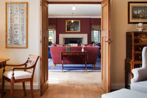Living room area with open doors and cushioned chairs in the room