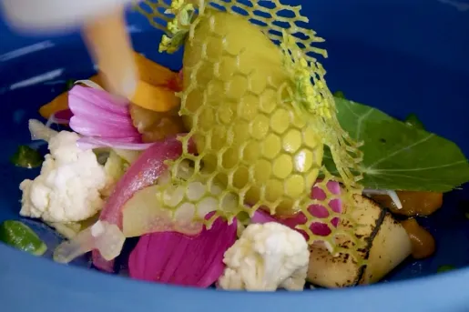Blue bowl full of roasted vegetables and plated