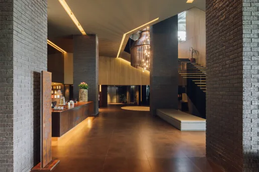 Hotel lobby with exposed stone and a stairway on the right