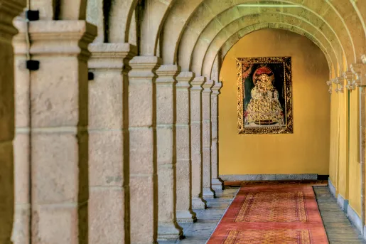 long hallway lined with columns and portrait at the end