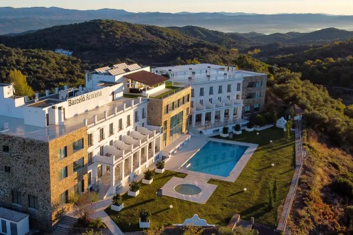 Large top-view shot of a hotel with outdoor pool