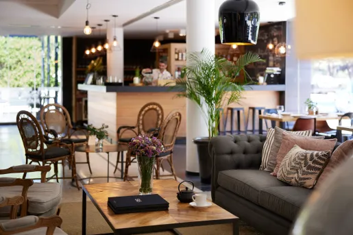 Bar with chairs and couches and a bartender in the background