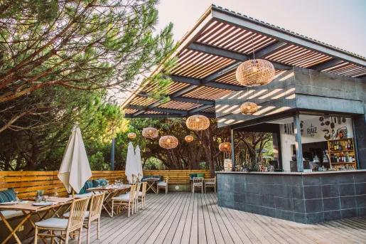Outdoor bar with woven ceiling light fixtures and wooden chairs