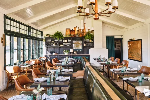 Dining area with green and brown leather sets and folded handkerchiefs on the tables