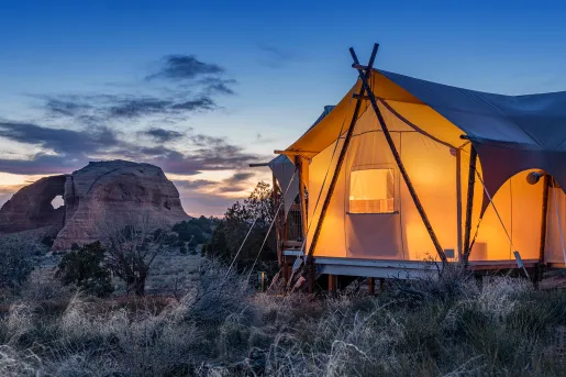 Glamping tent lit up in the desert