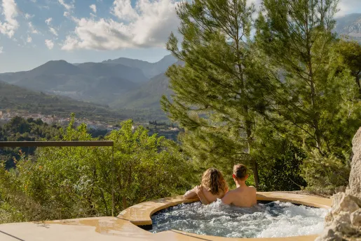 Two people in a hot tub overlooking a canyon