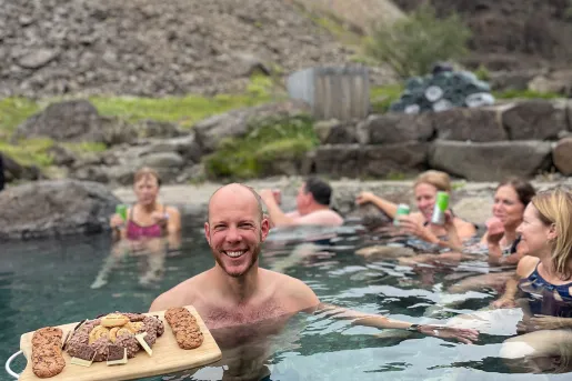 Man in a pool holding a cutting board full of cookies