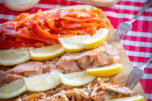 Wooden plank full of cured fish and lemon slices