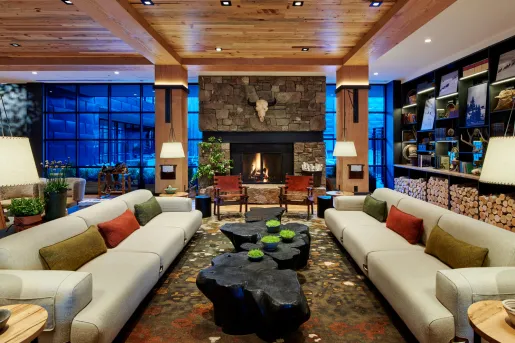 Lobby hotel with couches, black wood coffee tables and a stone fireplace