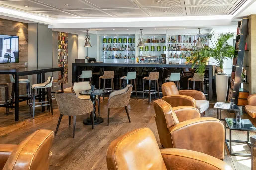 Bar and lounge with a bar counter and alcohol wall in the background