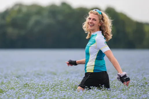 Woman smiling while walking through a field of lavender flowers