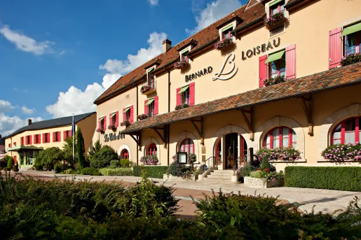 Exterior orange hotel building surrounded by trimmed bushes