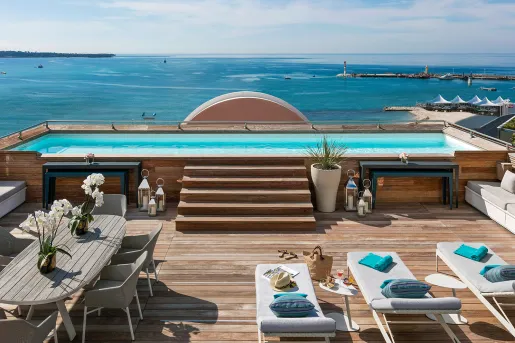 Outdoor patio with a pool looking out to the ocean