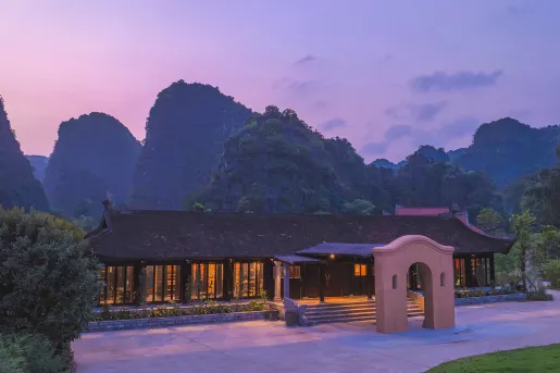 Exterior view of building with sunset and large mountains in the background