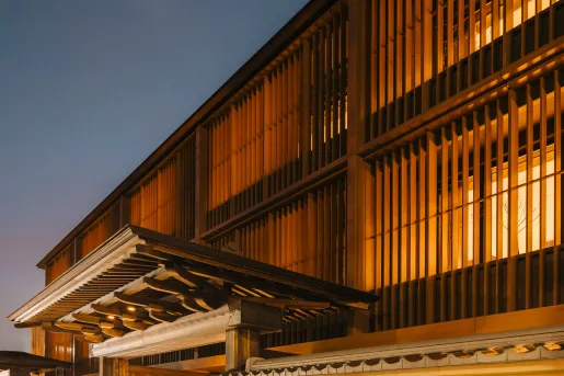 Exterior view of wooden temple building with illuminated rooms inside