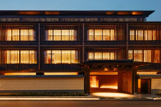 Exterior view of Japanese building with illuminated rooms and a road in front