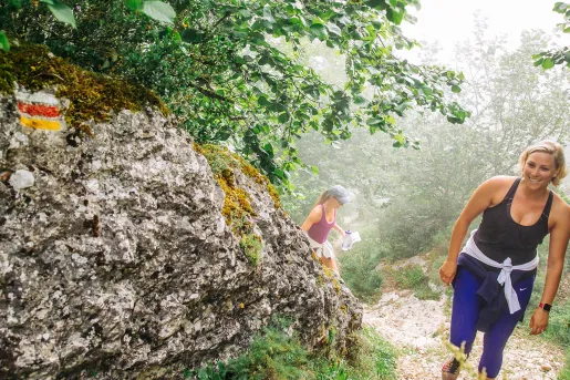 Two women hiking up a mountain while smiling
