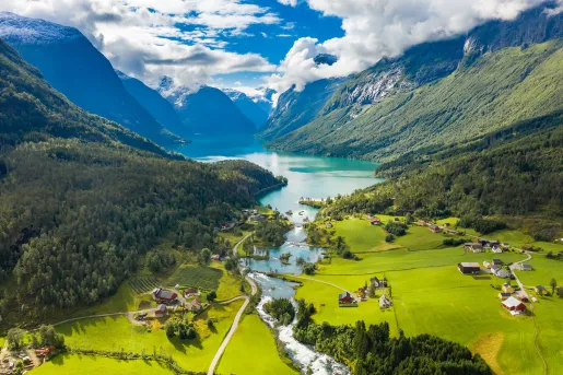 Large valley with houses and crop fields, with a lake in the distance
