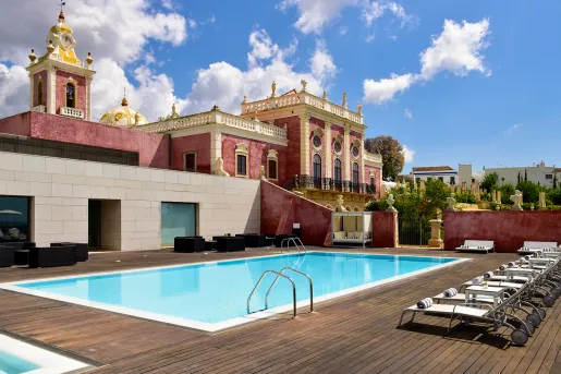 Outdoor pool with a red hotel building in the background