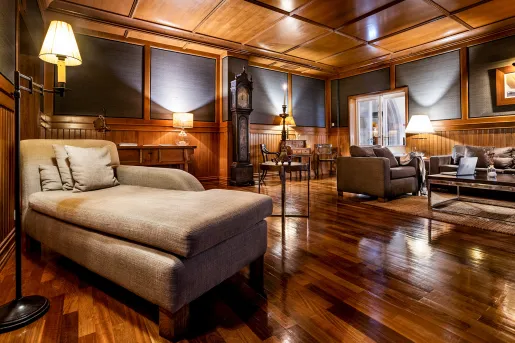 Lounge with wood flooring and walls, with lounge couches in the room
