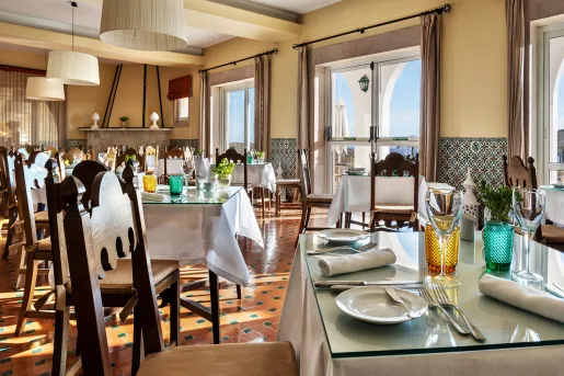 Restaurant with white dining tables and large windows in the background