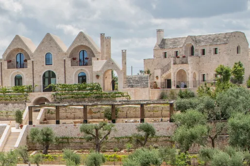 Exterior view of rustic, stone buildings with large gardens in front