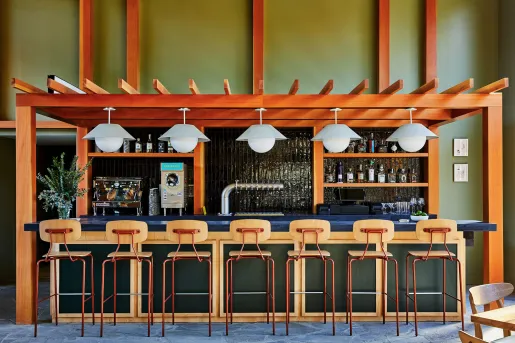 Bar with blue counter and wooden stools in front