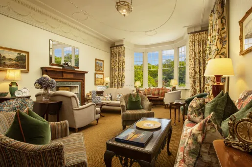 Lounge and seating area with cushioned chairs and large curtains in front of the windows