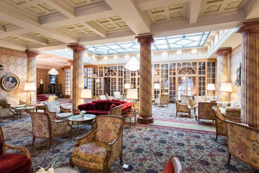 Indoor lobby and lounge with cushioned chairs and giant stone pillars
