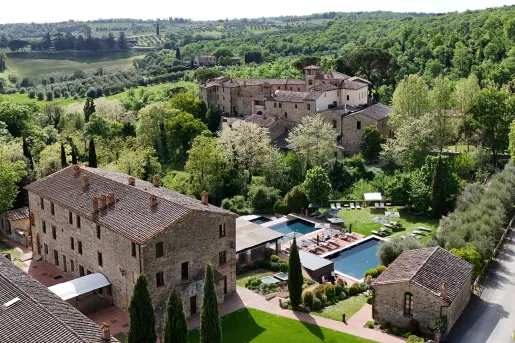 Sky view of stone hotel buildings with outdoor pools in front