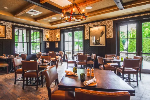 Hotel restaurant with wooden tables and chairs, with large windows