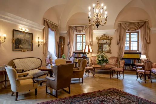 Indoor seating area and lounge with cushioned chairs and mini libraries along the wall