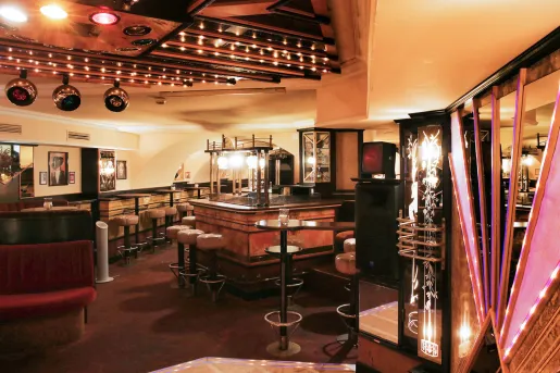 Bar and lounge with leather stools and dimly lit tables
