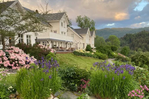 Exterior white building with a garden on a hill in front