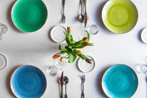 Four green and blue plates on a white table