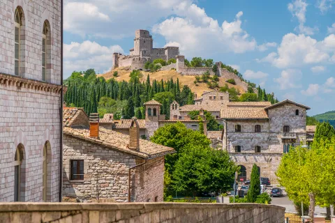 Wide shot of brick villages, large brick building on hilltop.