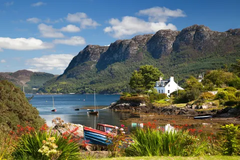 Lake with boats by the shore, and large mountains in the background