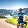 A biker taking a photo of a countryside European landscape.