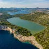 Large forest with a lake in the center, with the ocean to the left of the cliff