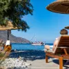 People sitting on reclining chairs by the shore of an ocean